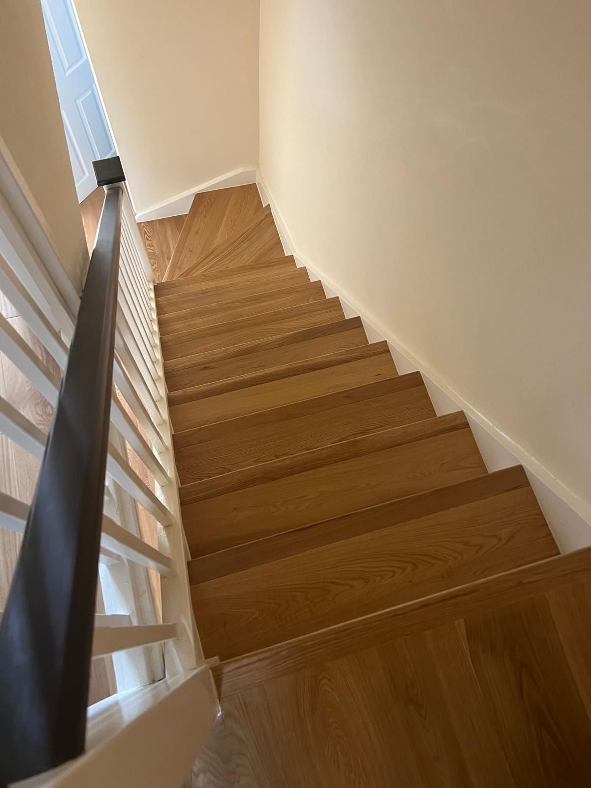 Looking down a natural oak engineered wood staircase