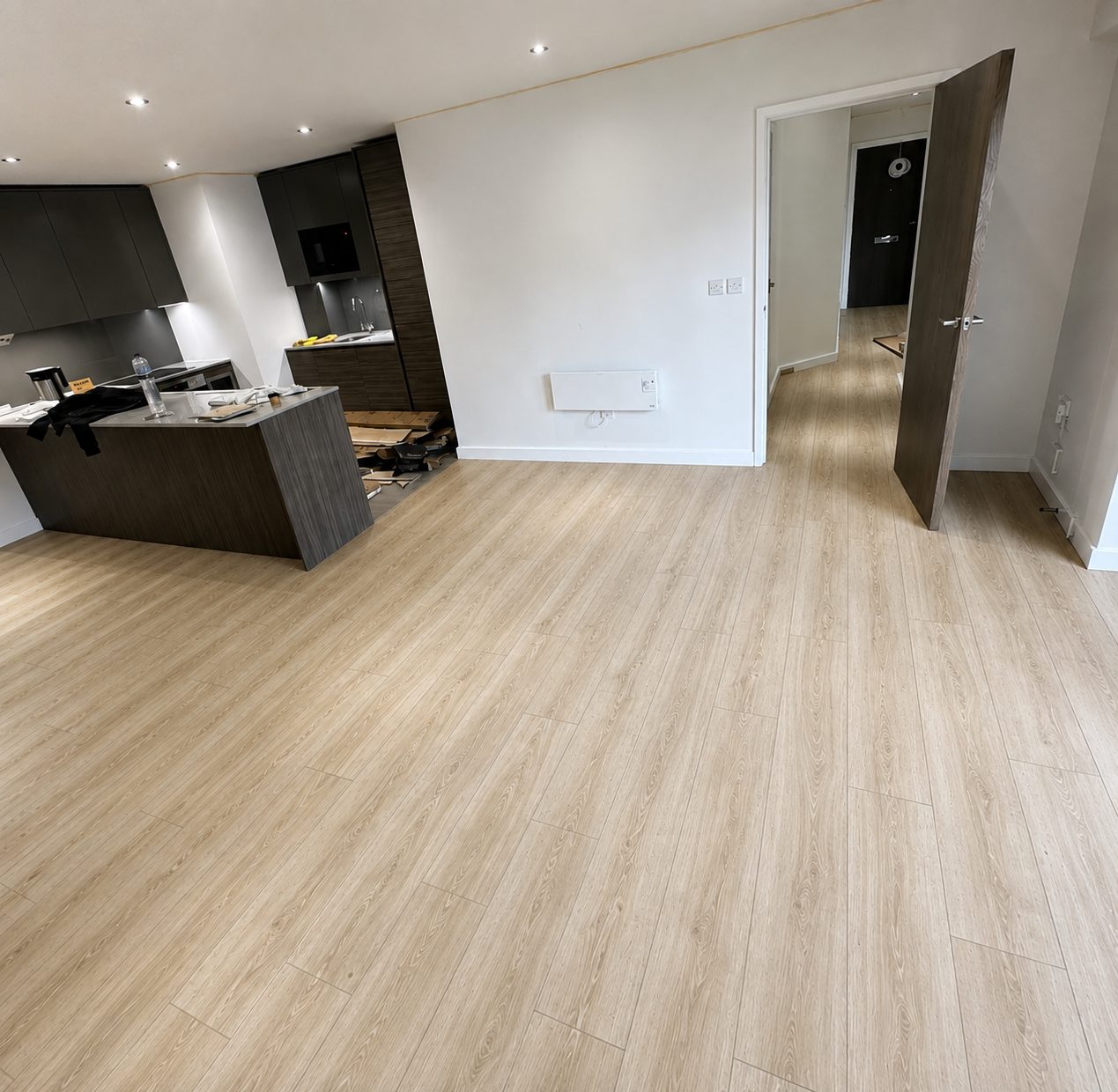 Light natural oak laminate flooring in an open-plan kitchen and living area