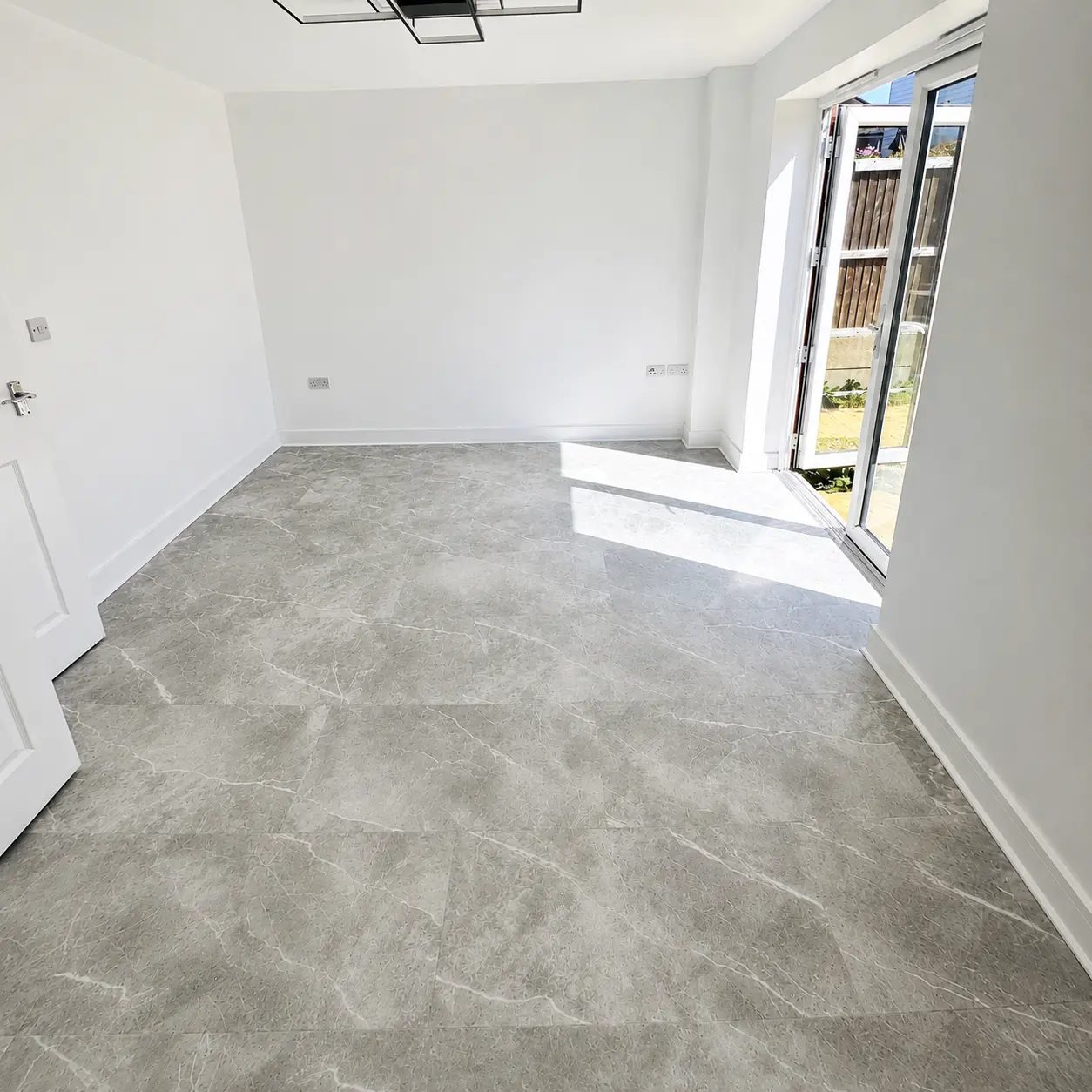 Large-format grey marble-effect LVT flooring in a white room