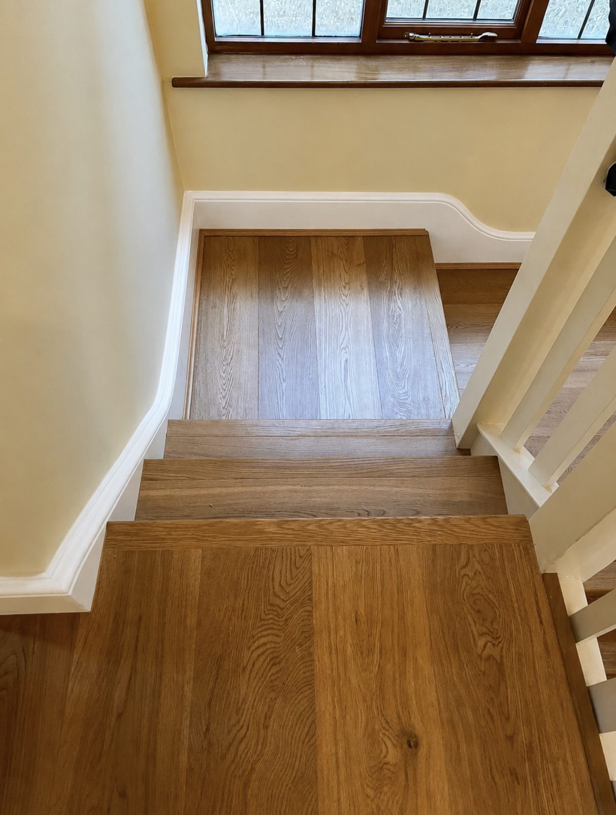 Oak staircase leading down to a matching timber landing