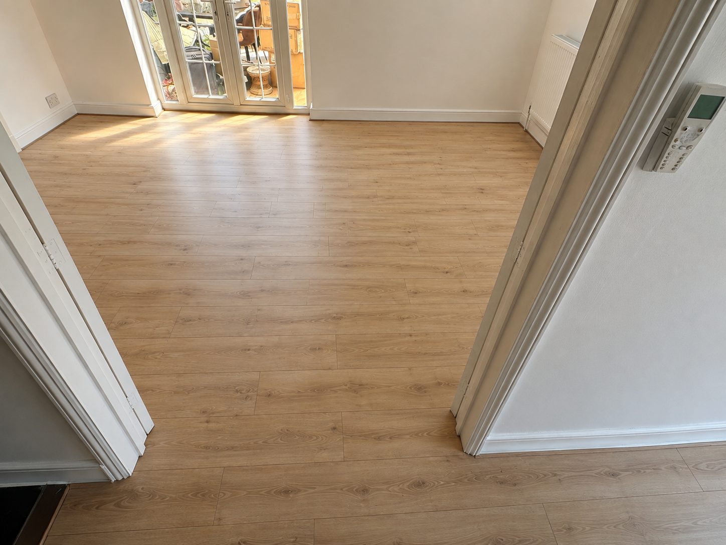 Natural oak laminate flooring fitted through a hallway and reception room